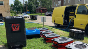 Industrial drying equipment and a service van set up for water damage restoration by Triple Crown Restoration in Covington, KY