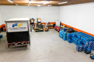 A warehouse filled with blue air movers and drying equipment used for water damage restoration by Flood Pros in Sandy, UT.