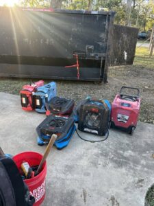 Industrial air movers and a large dumpster used for water damage restoration projects by Elements of Restoration in Denver, CO.