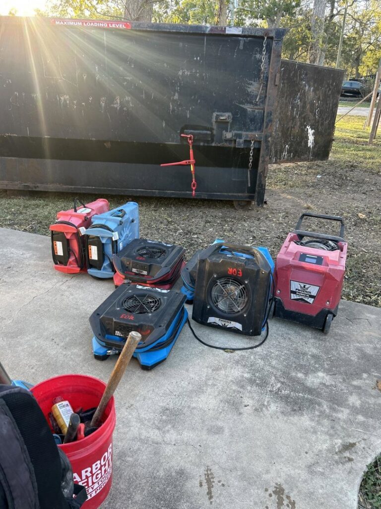 Industrial air movers and a large dumpster used for water damage restoration projects by Elements of Restoration in Denver, CO.