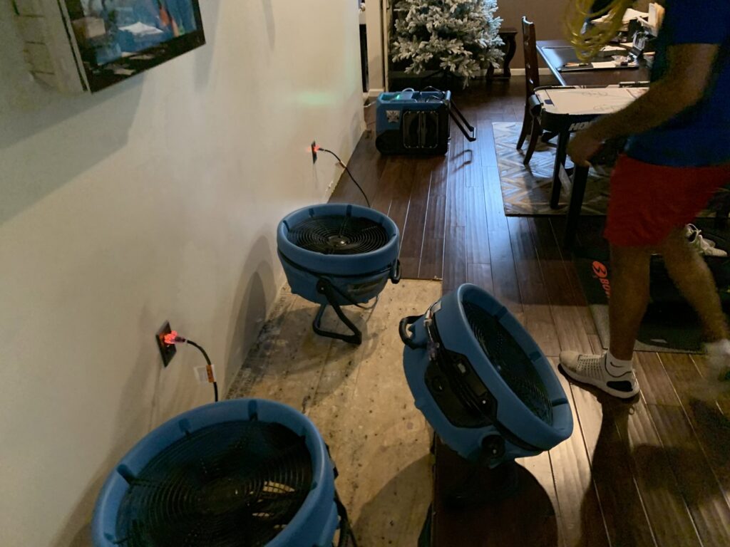 Industrial fans and air movers actively drying a residential floor after water damage by Prime Restoration in Lancaster, PA.