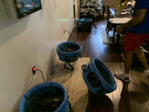 Industrial fans and air movers actively drying a residential floor after water damage by Prime Restoration in Lancaster, PA.