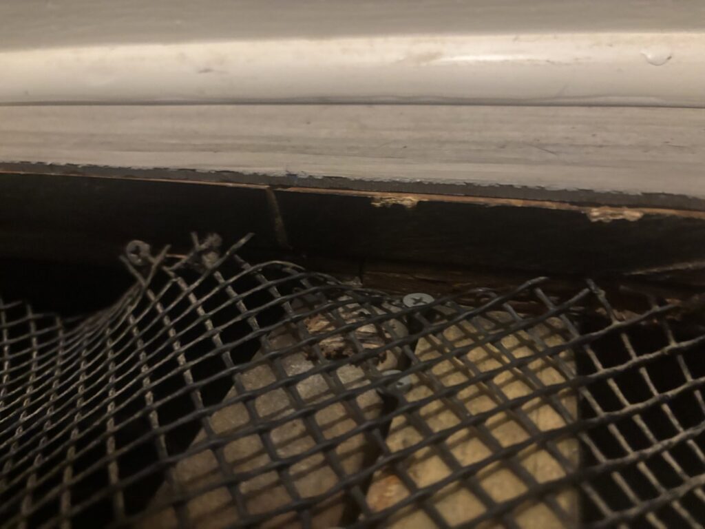 Close-up of a floor vent showing significant water damage and discoloration on the surrounding flooring, indicating a need for water damage restoration by COIT Cleaning and Restoration in Indianapolis, IN.