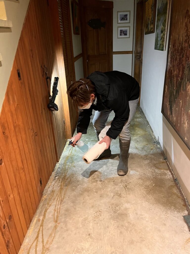 A Paul Davis Restoration of Greater Portland, ME specialist inspecting a water-damaged floor during cleanup in Falmouth, ME.