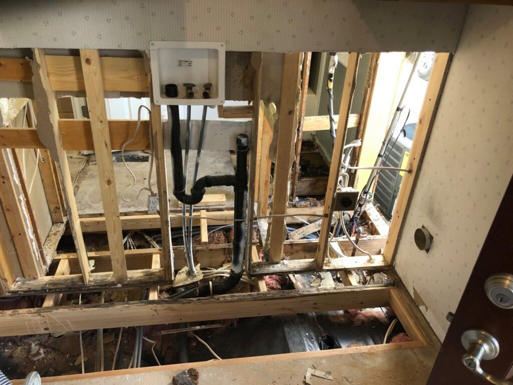 Water damage remediation showing exposed subfloor, wall studs, and plumbing in a damaged area in Boise/Meridian, ID