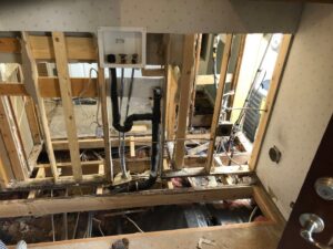 Water damage remediation showing exposed subfloor, wall studs, and plumbing in a damaged area in Boise/Meridian, ID