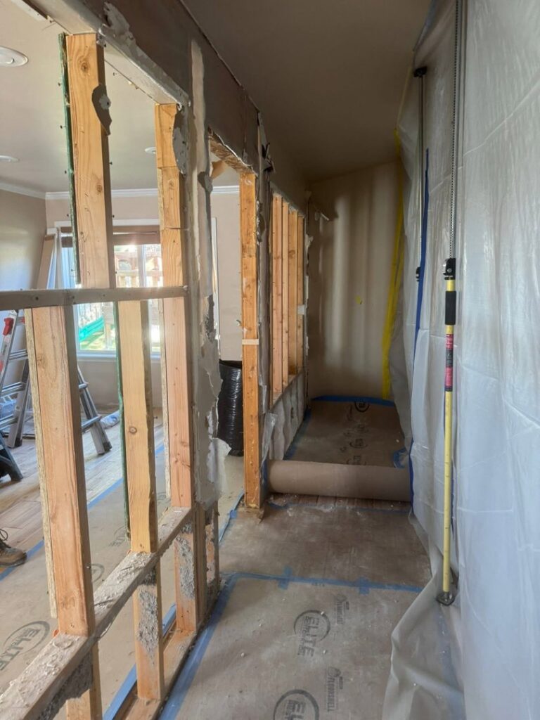 An interior space with exposed wall studs and plastic sheeting, indicating water damage restoration by Highway Renovation in Twin Falls, ID.