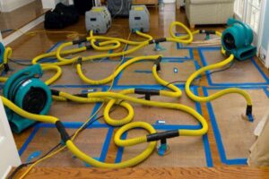 Water damage restoration equipment, including air movers and dehumidifiers, drying a floor by Emergency Response Services Inc. in Warren, MI
