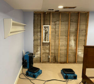 Water damage restoration equipment and an exposed wall in a home being restored by RestoPros of Salt Lake City, UT