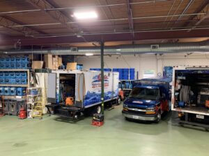 Water damage restoration equipment and vehicles inside the Providence Fire Restoration facility in Pawtucket, RI.
