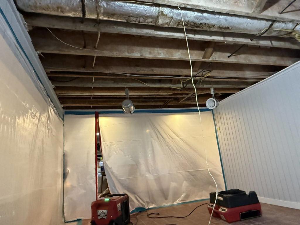 Water damage restoration equipment, including dehumidifiers and plastic sheeting, set up by Express Restoration in Edmond, OK.