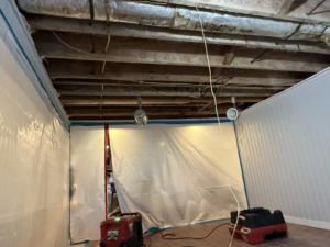 Water damage restoration equipment, including dehumidifiers and plastic sheeting, set up by Express Restoration in Edmond, OK.