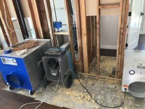 Water damage restoration with exposed wall studs, dehumidifier, and air mover by Best Dry Flood and Mold Specialists, Inc. San Diego, CA