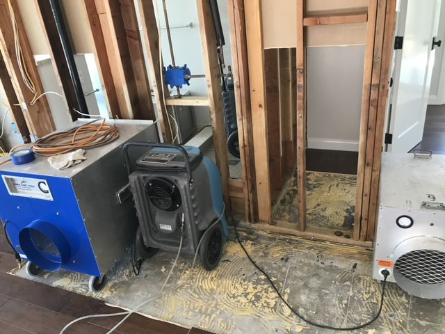 Water damage restoration with exposed wall studs, dehumidifier, and air mover by Best Dry Flood and Mold Specialists, Inc. San Diego, CA