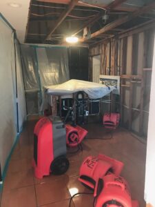 A water damage restoration site with containment barriers and drying equipment by EZ Water Damage Restoration Services in Chula Vista, CA.
