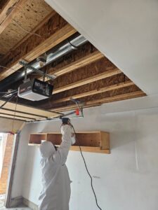 A Water Damage, Inc. specialist in a hazmat suit and respirator performing remediation work in Denver, CO.