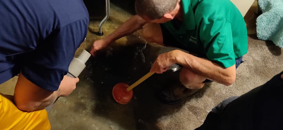 Water damage specialists from Hauser Dry Water Damage Restoration and Mold Remediation removing water from a flooded floor in Rochester, MN.