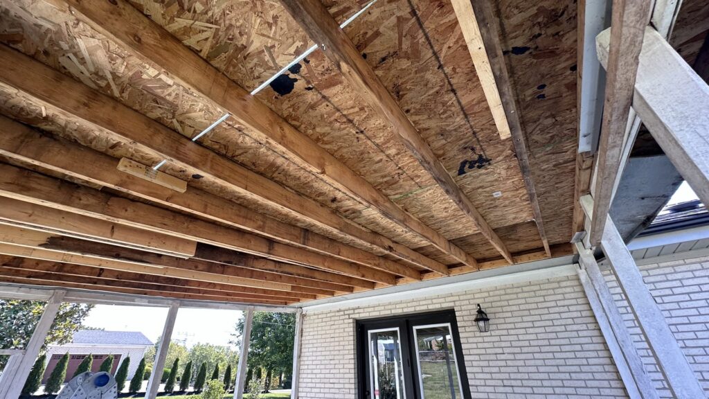 Water-stained wood sheathing under a porch, showing damage requiring specialist repair by Patriot's Handyman and Remodeling in Richmond, KY.