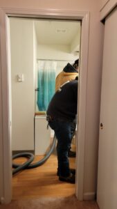 Water damage technicians working in a bathroom, possibly performing water extraction, for Robinson Restoration in Vancouver, WA