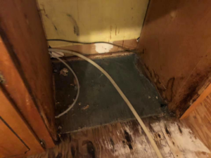 Close-up of water damage and discoloration under kitchen cabinets, indicating a need for restoration by One Stop Dry Out Restoration of Arkansas in North Little Rock, AR.