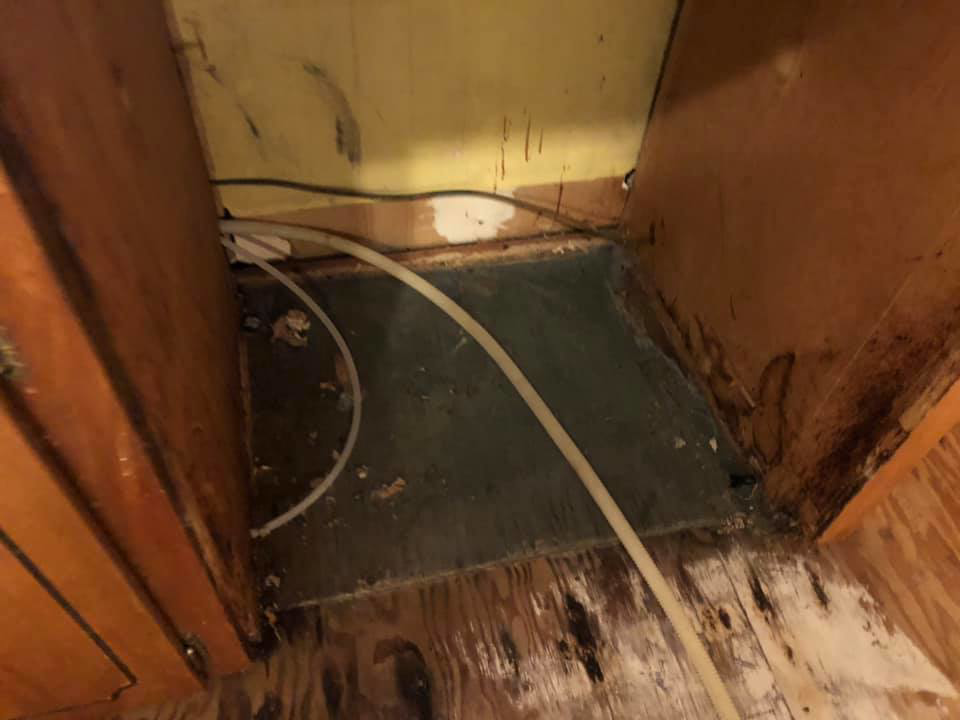 Close-up of water damage and discoloration under kitchen cabinets, indicating a need for restoration by One Stop Dry Out Restoration of Arkansas in North Little Rock, AR.