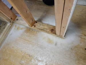 Visible water damage and moisture stains on a wooden floor, indicating a need for water damage restoration by Dakota Fire and Water Restoration in Bismarck, ND.