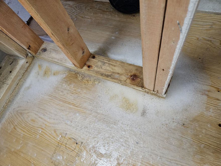 Visible water damage and moisture stains on a wooden floor, indicating a need for water damage restoration by Dakota Fire and Water Restoration in Bismarck, ND.