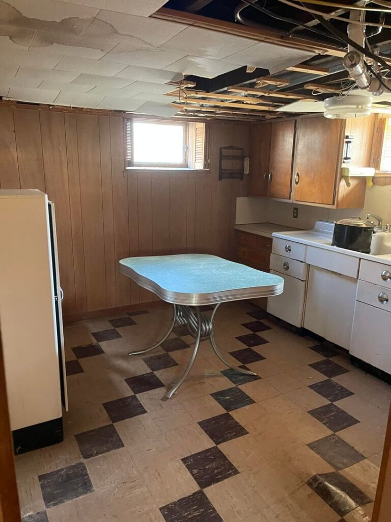 A basement kitchen ceiling showing clear water stains and damage, ready for repair by Mac Construction in Cranston, RI