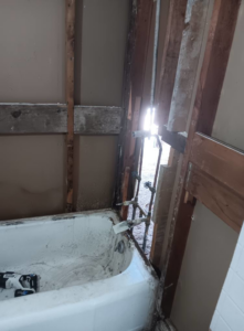 Water damaged bathroom wall demolition with exposed studs by Integrity Solutions in Omaha, NE.