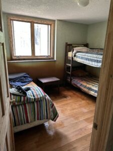 A water-damaged bedroom with wet wooden floors and stained walls, indicating a need for Restoration Alliance Services in Elk River, MN.