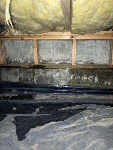 A severely water-damaged crawl space with standing water and mold, requiring restoration by APEX Restoration in Mililani, HI