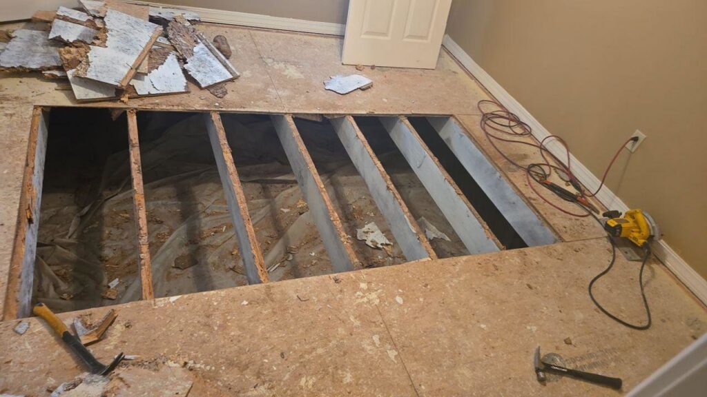 A water-damaged floor undergoing demolition, exposing joists, by Restoration Xperts Emergency 24/7 in Deerfield Beach, FL.