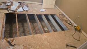 A water-damaged floor undergoing demolition, exposing joists, by Restoration Xperts Emergency 24/7 in Deerfield Beach, FL.