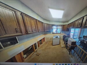 A room with water damage on the floor and removed baseboards and drywall by Dayspring Restoration in Butte, MT