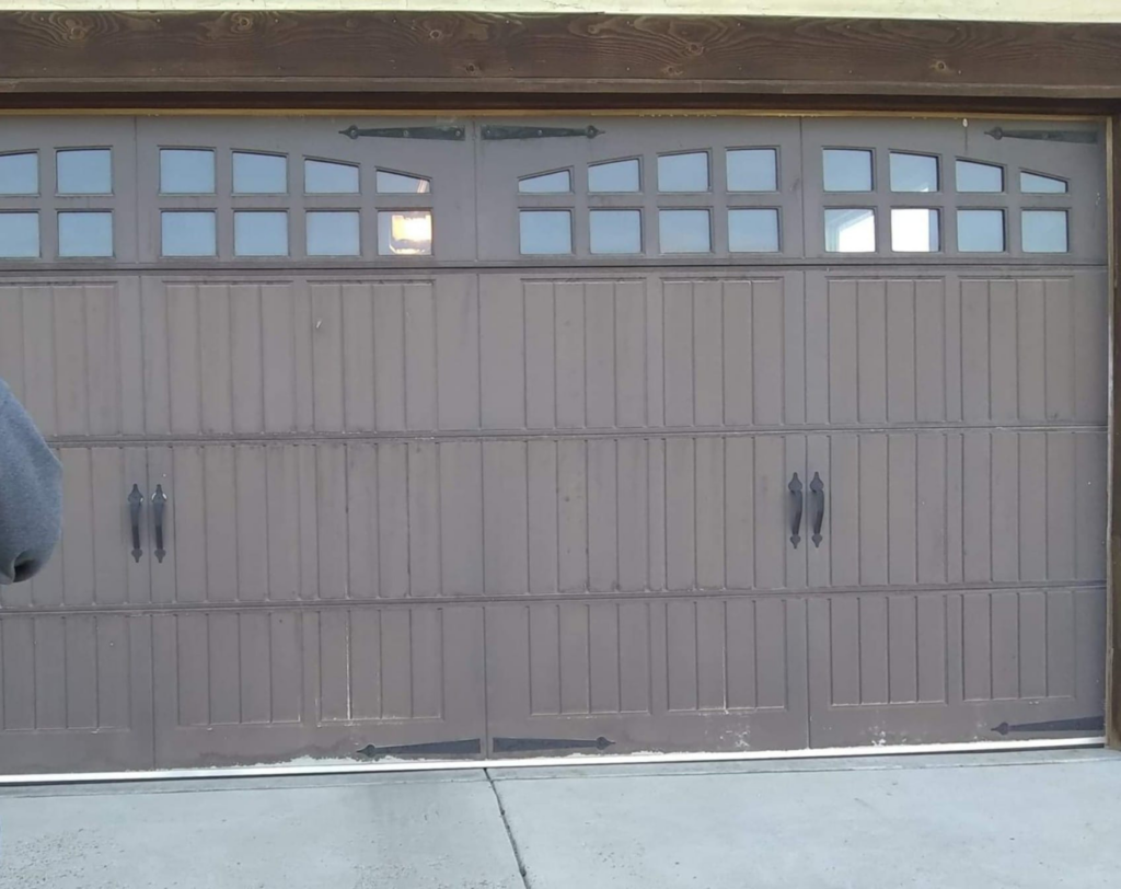 A garage door with clear water damage and peeling paint at the bottom, restored by R&R Residential Restoration & Customization in Casper, WY.