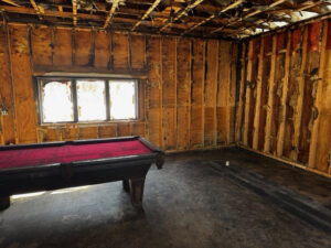 A room with extensive water damage and exposed studs during demolition by RestoPros of Eastern & Central Maine in Bangor, ME.