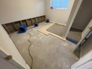 A room with removed drywall and industrial fans drying out water damage by Brothers Restoration in Post Falls, ID.