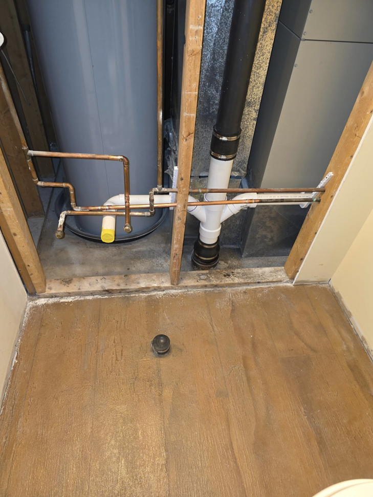 Extensive water damage on the subfloor in a utility area with a water heater, handled by JB'S Home Repair in Manhattan, KS.