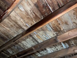 A water-damaged wooden ceiling with discoloration and potential mold, requiring remediation by Healthy Interior Solutions in Fishers, IN.
