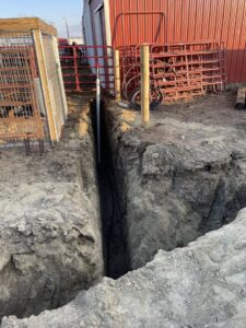 Water and drainage line installation in a trench near a barn by KD Services - Excavating in Bismarck, ND