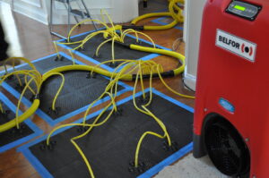 Water extraction and drying equipment on a wooden floor by Belfor Property Restoration, New Orleans, LA