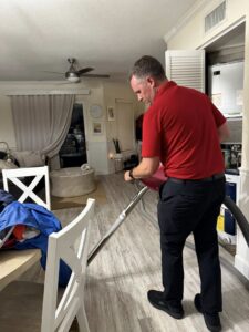 A technician performing water extraction and drying on a damaged floor in a home by PuroClean of Hilton Head in Bluffton, SC.