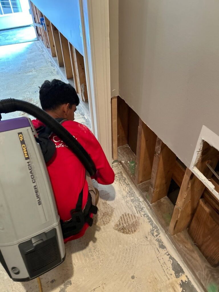 A technician performing water extraction and drywall removal during water damage restoration by Level Creek Property Restoration in Buford, GA.