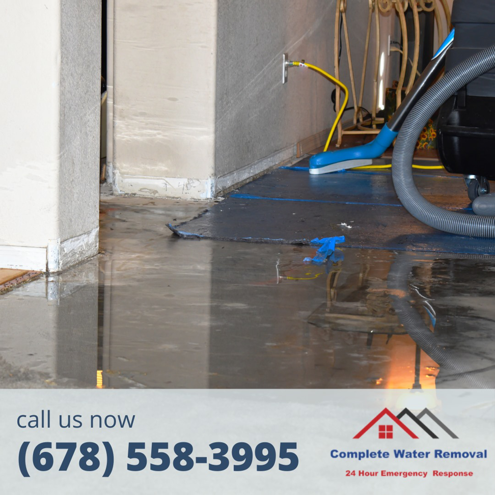 Water extraction equipment being used on a floor with standing water by Complete Water Removal and Restoration in Cumming, GA.