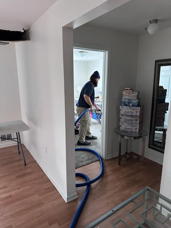 A technician performing water extraction from a carpeted floor using specialized equipment for Incore Restoration Group in Wixom, MI.