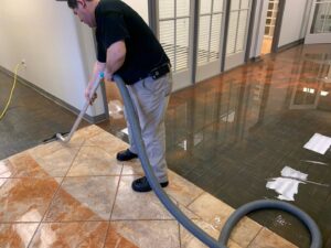 A Servpro technician performing water extraction from a tiled floor during a water damage cleanup in Athens, GA.