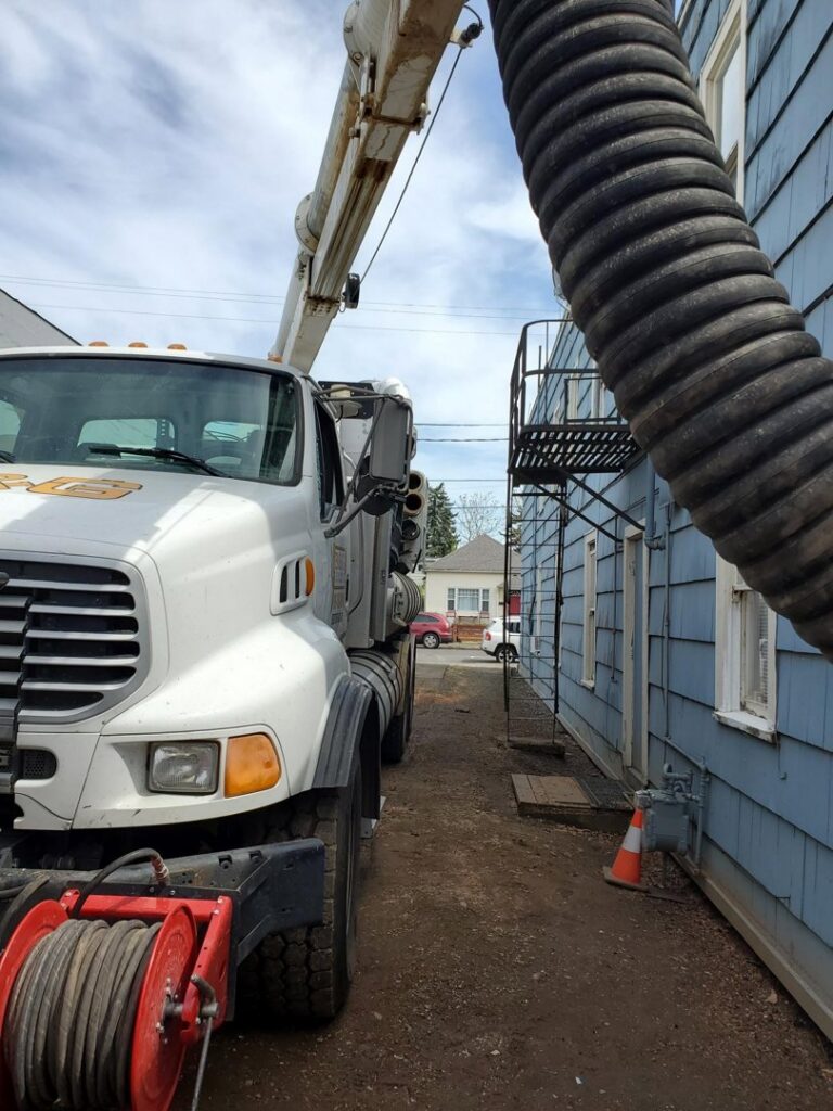 A large hose from a Paul Davis Restoration truck performing water extraction from a building in Vancouver, WA