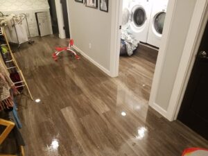Water flooding a laundry room and adjacent hallway, showing significant water damage, by Elite Restoration LLC in Puyallup, WA.