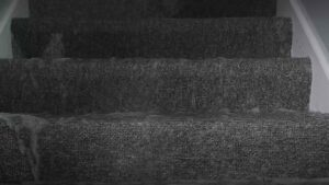 Water flowing down carpeted stairs, indicating severe water damage, in York, PA, handled by 1-800 Water Damage of Harrisburg, PA.