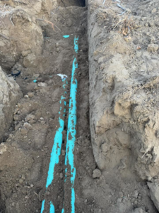 Blue water pipes being installed or repaired in a trench by MP-X LLC Excavation and Construction in Riverton, WY